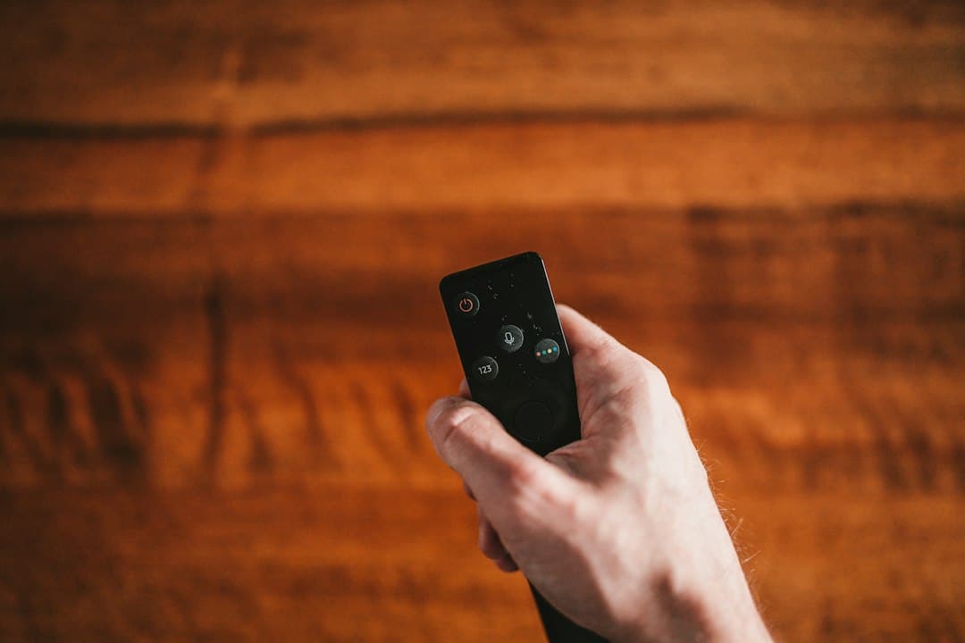 Main tenant une télécommande, prête pour configurer Pure IPTV sur IPTV Smarters Pro